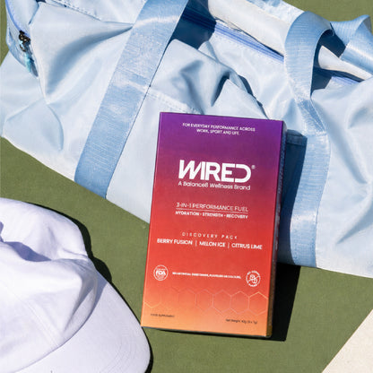 WIRED Discovery Pack – lifestyle flatlay on gym bag with white cap on tennis court | Balance8 Wellness