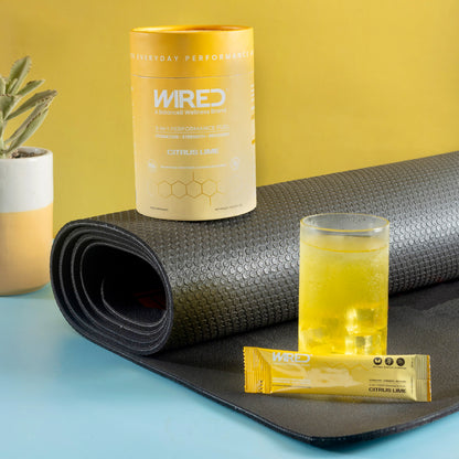 WIRED Citrus Lime – active routine lifestyle shot with canister, sachet, mixed drink and yoga mat | Balance8 Wellness